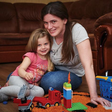 Eine Mutter und ihre Tochter spielen zuhause.