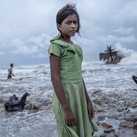 Die zwölfjährige Pallavi steht vor dem Wasser, das ihr Zuhause weggeschwemmt hat.