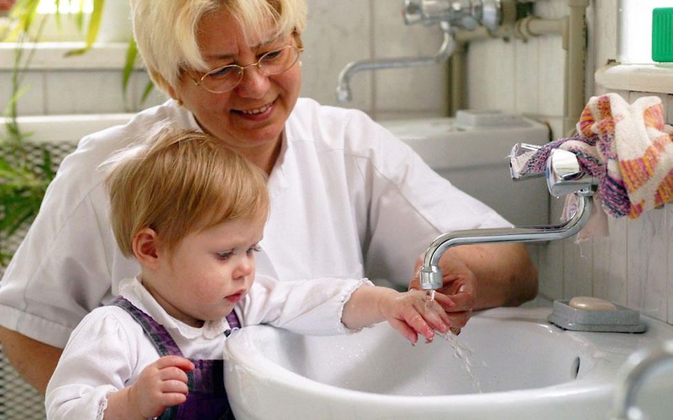 Eine Waisenhaus-Mitarbeiterin hilft einem Mädchen beim Hände waschen © UNICEF/ HQ04-0697/Giacomo Pirozzi