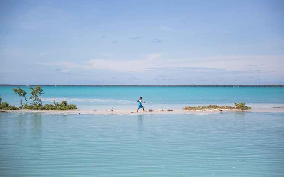 Eine Junge in Kiribati auf dem Weg von der Schule nach Hause.