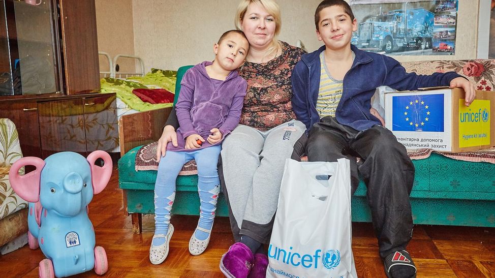 Eine Familie sitzt auf dem Sofa in ihrem neuen Zuhause.