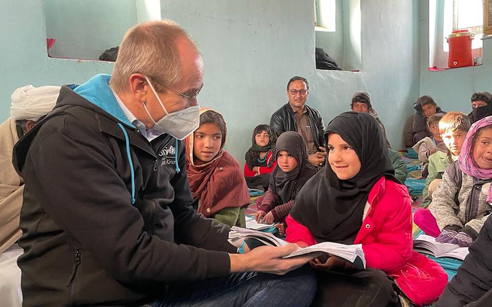 Afghanistan: Eine Schülerin liest UNICEF Deutschland Geschäftsführer Christian Schneider vor