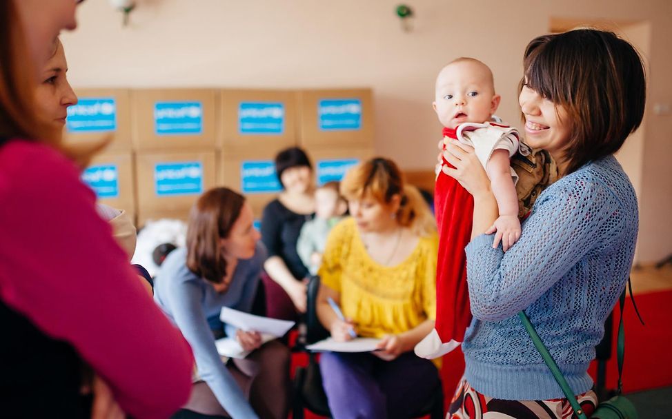 Eine UNICEF-Mitarbeiter*innen schulen Mütter zum Thema Stillen.