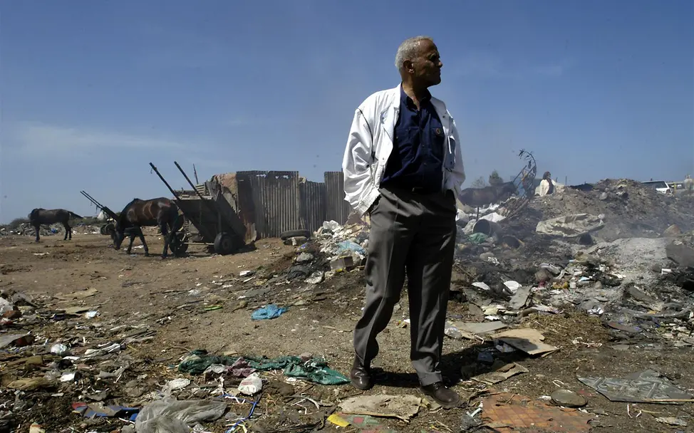 Harry Belafonte in einem Slum von Dhaka, Senegal | © UNICEF/Nesbitt Belafonte steht inmitten von Müllbergen in einem Slum von Dhaka