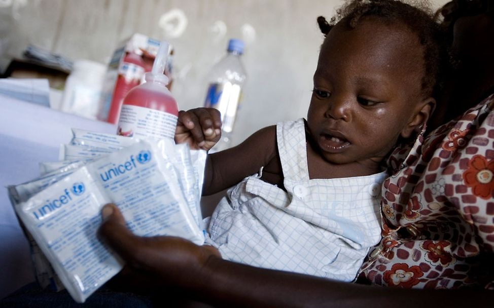 Eine Mutter und ihre Tochter mit einer Mischung aus Salz und Zucker © UNICEF/Marco Dormino