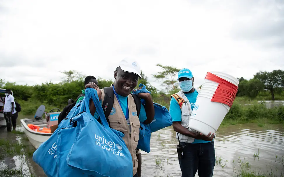 UNICEF Mitarbeiter helfen bei der Aufbereitung von sauberem Trinkwasser. | © UNICEF/Ryeng UNICEF Mitarbeiter stehen in einem Flussbett.