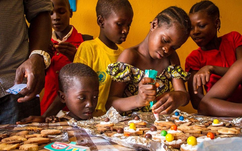 Kinder beim Plätzchen backen im Happy Center. © UNICEF Sierra Leone/Angela Griep