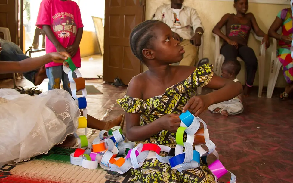 Ein Mädchen mit einer gebastelten Girlande. © UNICEF Sierra Leone/Angela Griep Ein Mädchen mit einer gebastelten Girlande. © UNICEF Sierra Leone/Angela Griep