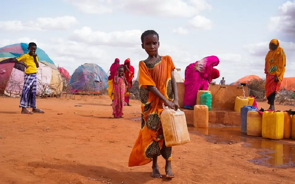 Hilfe für bedrohte Kinder dringender denn je | © UNICEF/UN0644298/Fazel Somalia: Mädchen trägt einen Kanister mit Wasser in einem Flüchtlingslager