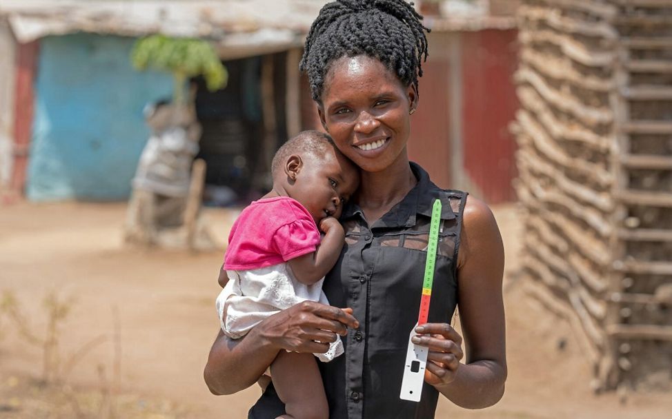 Mutter aus dem Südsudan hält Maßband in die Kamera.