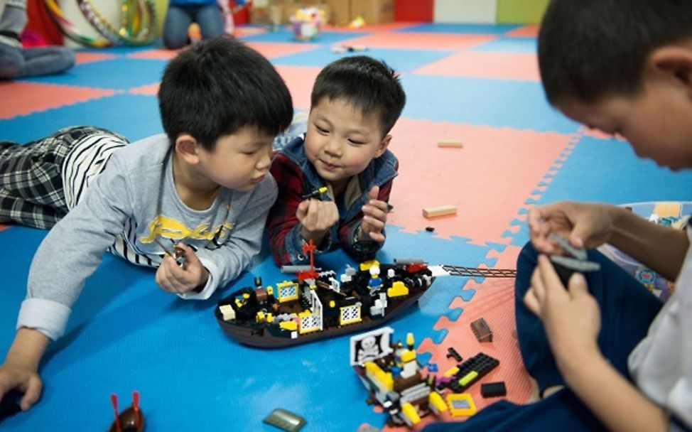 Kinder spielen mit Bausteinen.