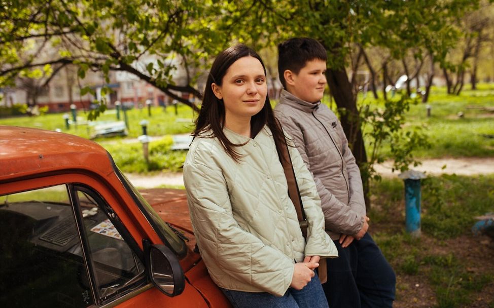 Ukraine: Sasha und ihr Bruder Ivan lehnen an ein Auto.