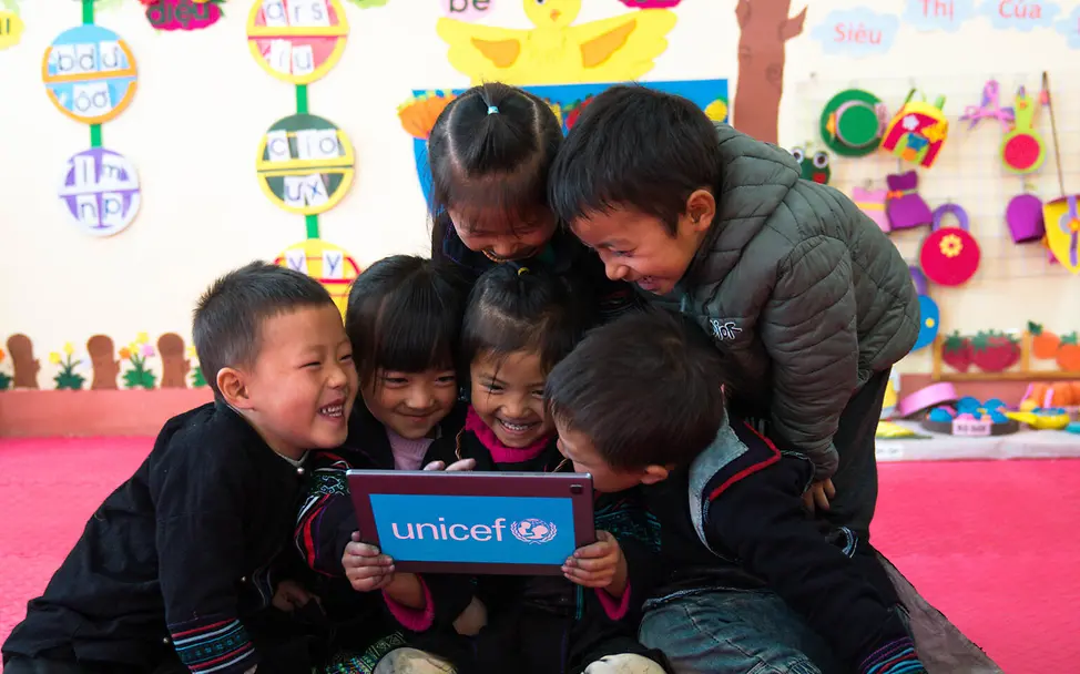 Hilfsgüter von UNICEF: Kinder in einer Vorschule freuen sich über Lernmöglichkeiten am Tablet.
