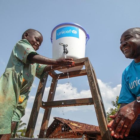 Humanitäre Hilfe Uganda: Ein Junge wäscht sich seine Hände unter Wassertank.