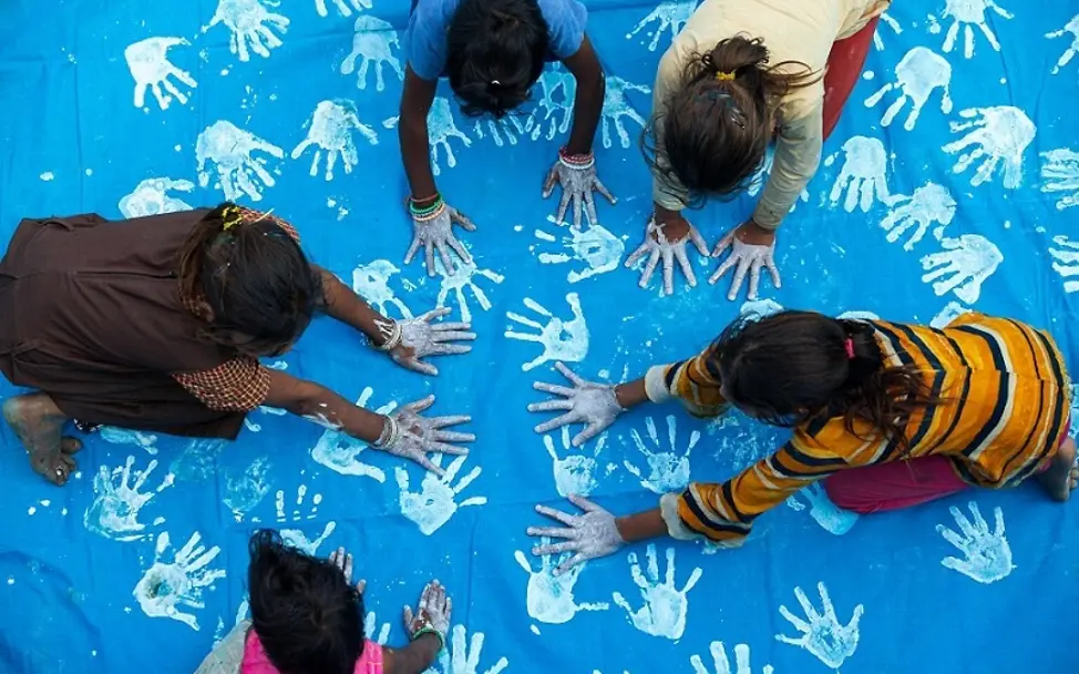 Auch Madhya Pradesh wird am Weltkindertag blau gefärbt. | © UNICEF/Soni Madhya Pradesh: Kinder färben ein blaues Tuch mit ihren Handabdrücken.