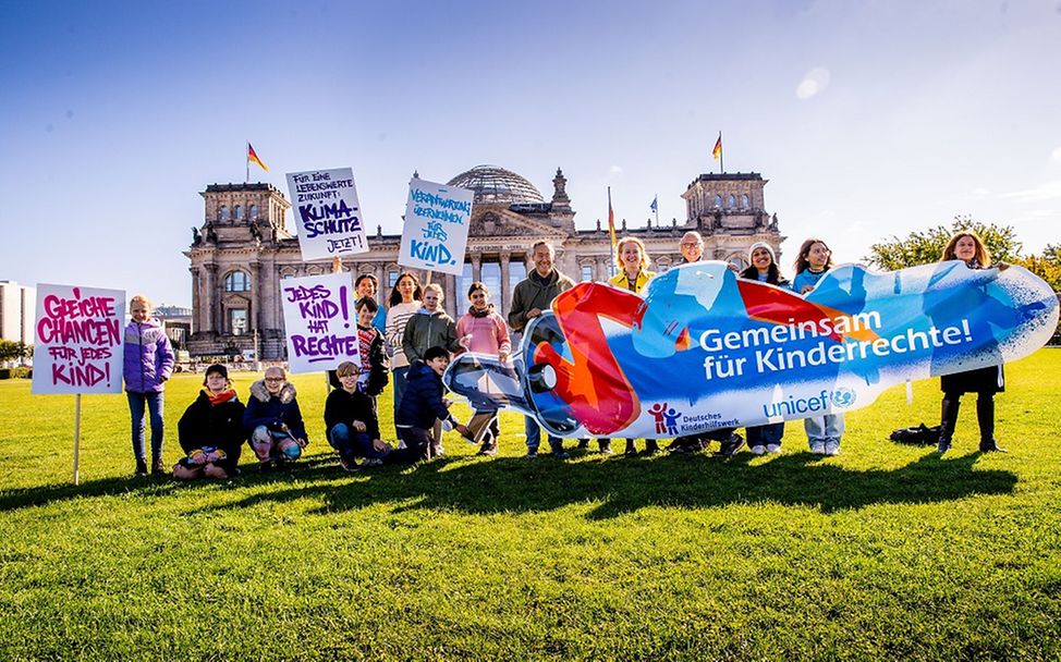 Kinder halten Plakate mit Forderungen hoch.