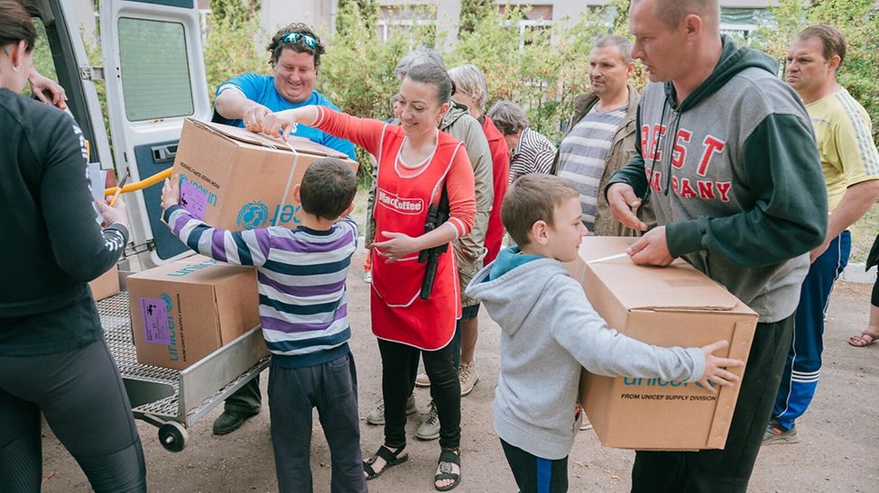 UNICEF | Hilfe für Kinder in der Ukraine: Kinder nehmen Hilfspakete von UNICEF entgegen.