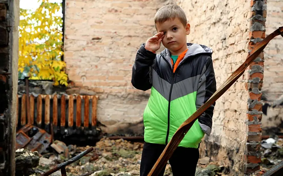 Nothilfe Ukraine: Ein Junge im Oblast Kiew steht in den Trümmern seines früheren Zuhauses. | © UNICEF/Boiko Nothilfe Ukraine: Millionen Kinder brauchen wegen dem Ukraine-Krieg humanitäre Hilfe.