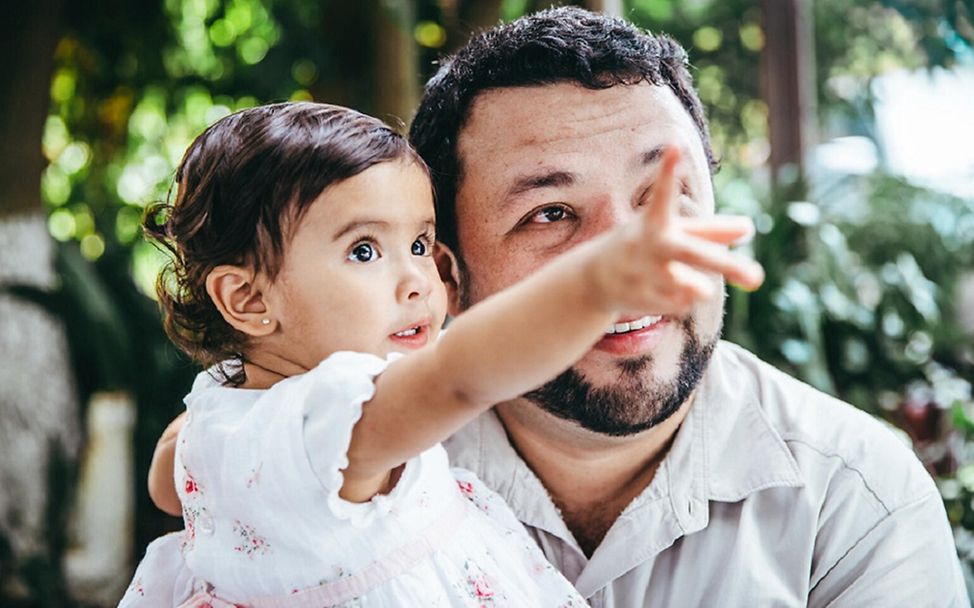 Guatemala: Ein kleines Mädchen zeigt ihrem Vater einen Vogel im Baum.