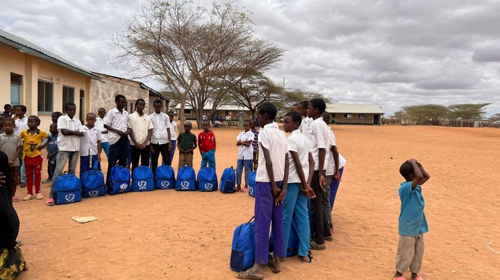 Kenia: Kinder stehen vor ihrer Schule mit den UNICEF-Rucksäcken