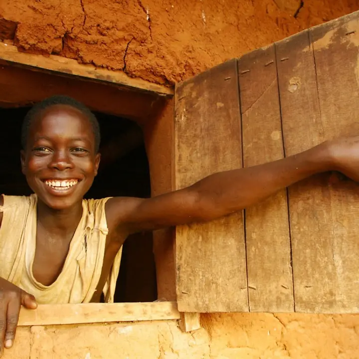 Ein Junge schaut lächelnd aus einem Fenster, © UNICEF/BENA2004-00270/Pirozzi Ein Junge schaut lächelnd aus einem Fenster, © UNICEF/BENA2004-00270/Pirozzi