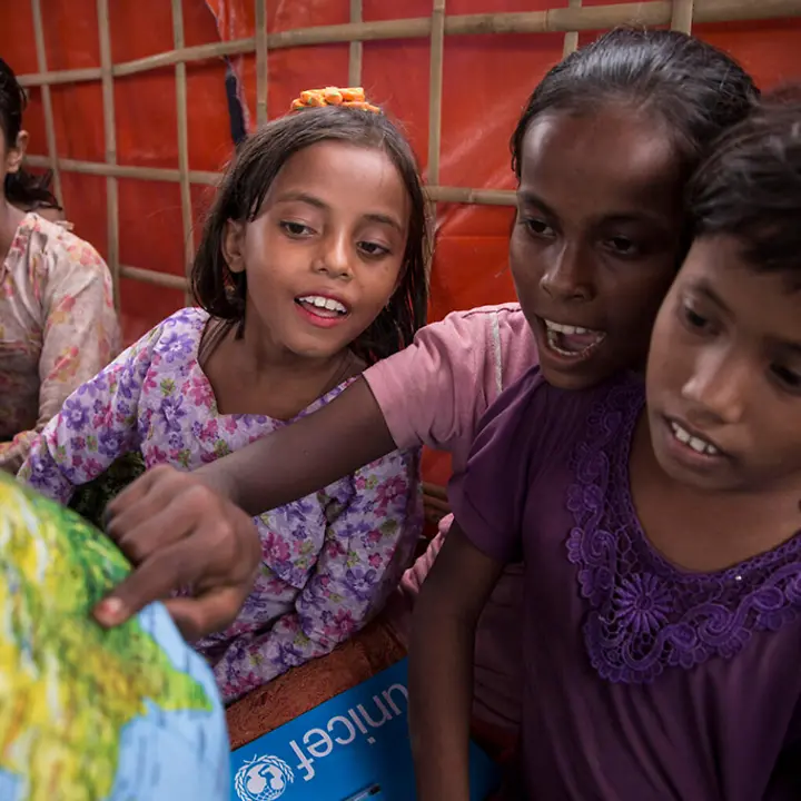 Eine Gruppe Schülerinnen verwenden den Globus der Schule in der Kiste