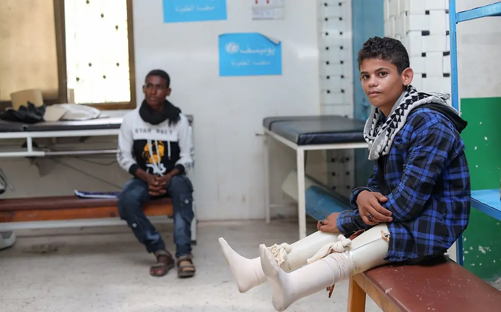 Mehr als 11.000 Kinder im Jemen getötet oder verletzt I UNICEF/UN0538380/ Ein Junge mit Beinprothesen sitzt auf einer Bank in einem Prothesenzentrum.