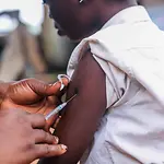 ein Kind bekommt über eine Spritze in den Arm eine Impfung verabreicht, die es vor Masern schützt.