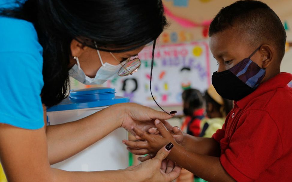 Venezuela Wasserversorgung: Eine UNICEF-Mitarbeiterin zeigt einem Jungen das Händewaschen. 