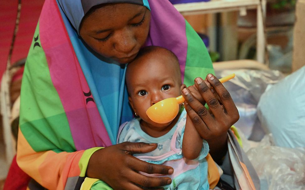 Eine Mutter füttert ihr Kind. | © UNICEF/Dejongh