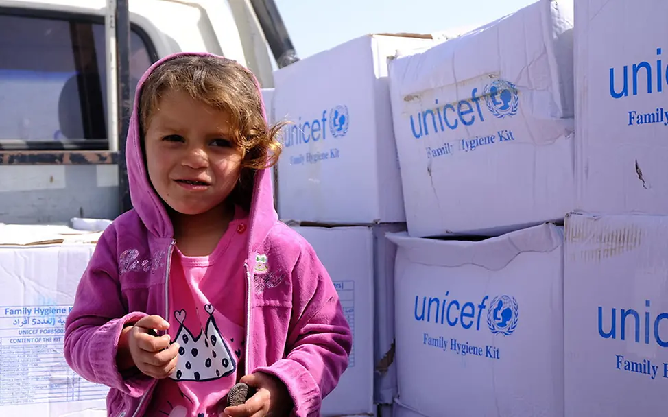 Syrien: Kind steht vor UNICEF-Hilfsgütern. I UNICEF/English Syrien: Kind steht vor UNICEF-Hilfsgütern.