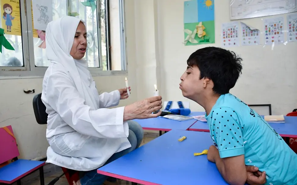 Aussprache üben im Förderunterricht. |© UNICEF/Shahan Syrien: Ahmad pustet die Kerze aus, die seine Lehrerin hochhält.
