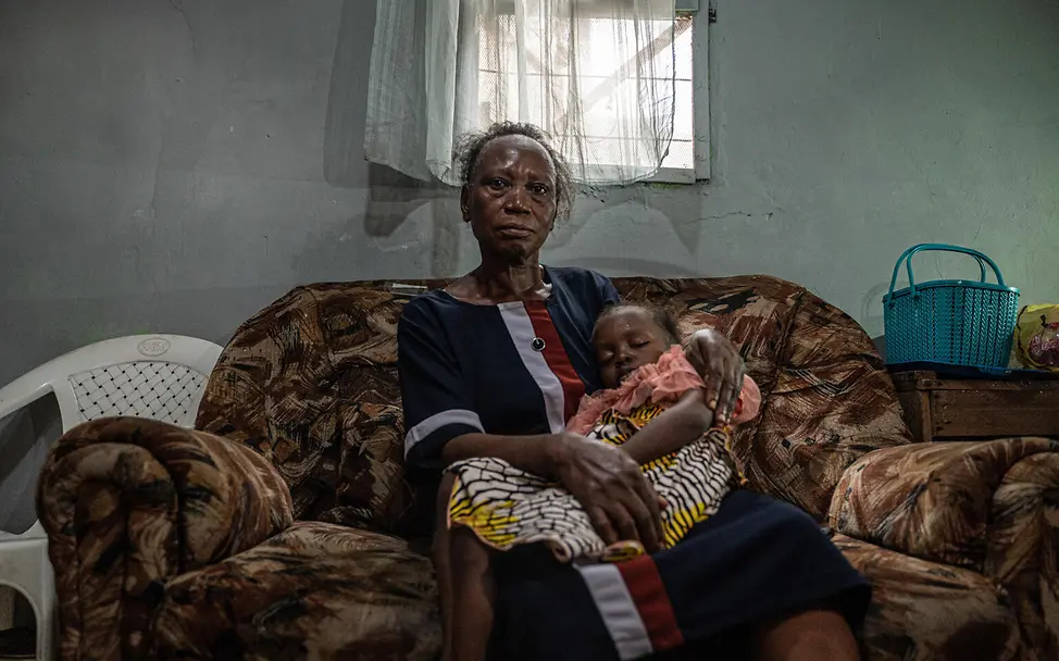 Eine erleichterte Oma kuschelt mit ihrer Enkelin: Nun ist Toluwalase geimpft. | © UNICEF/U.S. CDC/Unique Identifier/Nelson Apochi Owoicho Oma Victoria Aina kuschelt mit ihrer Enkelin, der 3-jährigen Toluwalase.