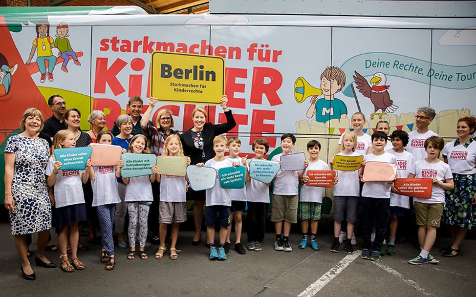 70 Jahre UNICEF Deutschland: Eine Gruppe von Kindern mit Betreuern vor dem Bus der Tour "Stark machen für Kinderrechte"