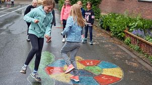 Kinderrechteschulen: Schüler*innen spielen auf dem Schulhof ein Hüpfspiel