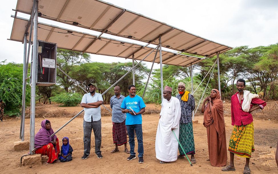 Dürre: UNICEF Wasserspezialisten und Dorfbewohner stehen vor dem neuen Wassersystem in Kenia.