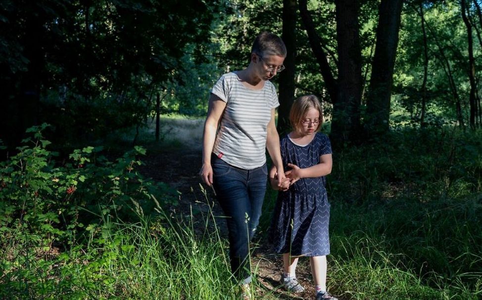 Hitze Kinder: Mutter und Tochter gehen im Wald spazieren