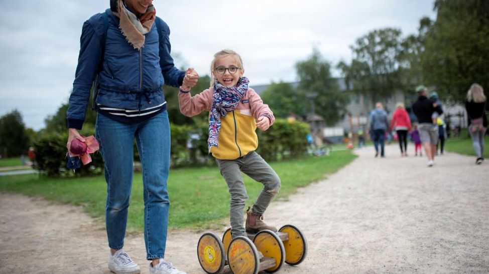 Deutschland: Mädchen fährt Pedalo und hält dabei die Hand einer Frau.