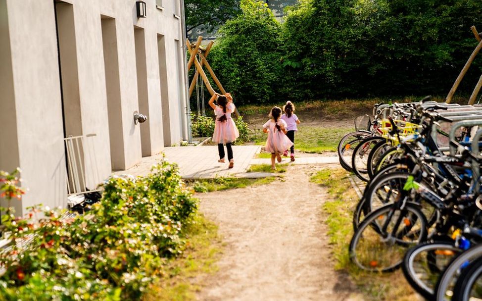 Kinder in einer Flüchtlingsunterkunft freuen sich über den Spielplatz.