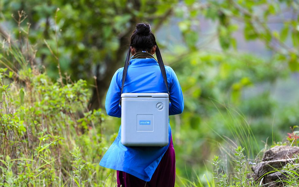 Eine Gesundheitshelferin in Nepal bringt gekühlte Impfstoffe zu Kindern.