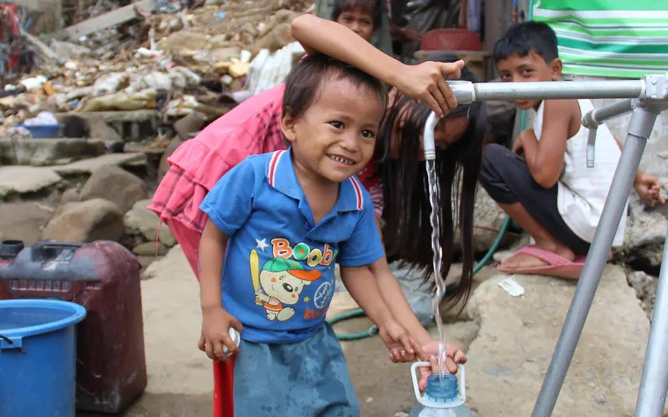 Junge von den Philippinen beim Abfüllen von Wasser. © Louise Lane Junge von den Philippinen beim Abfüllen von Wasser. © Louise Lane