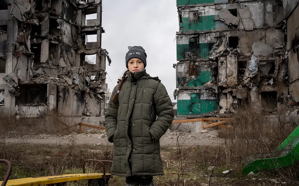 Kinder in der Ukraine brauchen weiter Hilfe | UNICEF/Filippov Die 10-jährige Veronika steht in den die Ruinen eines Hochhauses in der Ukraine.