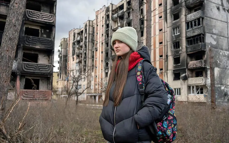 Ein Mädchen in der Ukraine läuft durch eine zerbombte Straße in Irpin | © UNICEF/Filippov Ukraine Nothilfe: Ein Mädchen läuft durch eine zerbombte Häuserlandschaft.