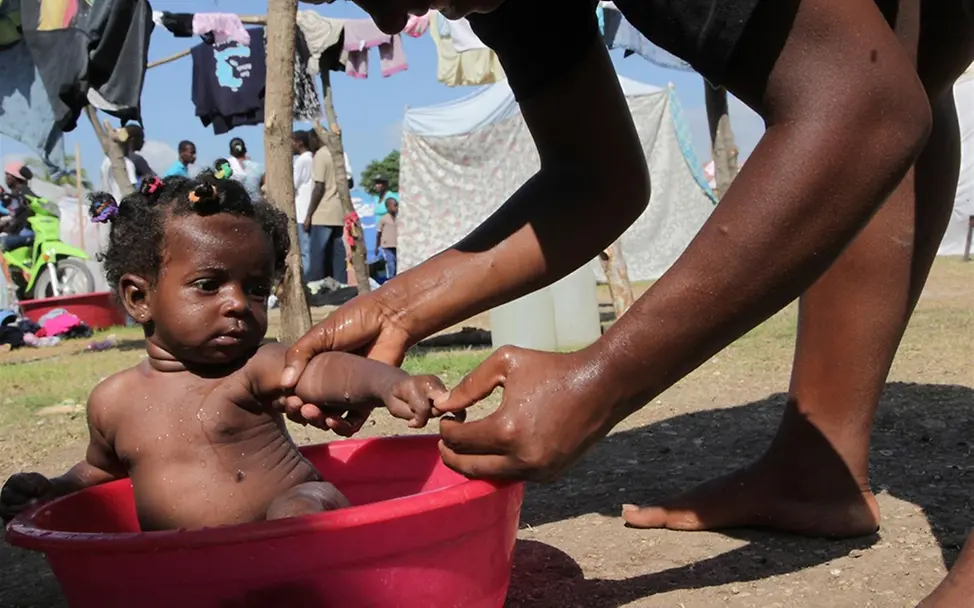 Haiti: Eine Mutter badet ihr Baby in einer Plastikbadewanne. © UNICEF/LeMoyne Haiti: Eine Mutter badet ihr Baby in einer Plastikbadewanne. © UNICEF/LeMoyne