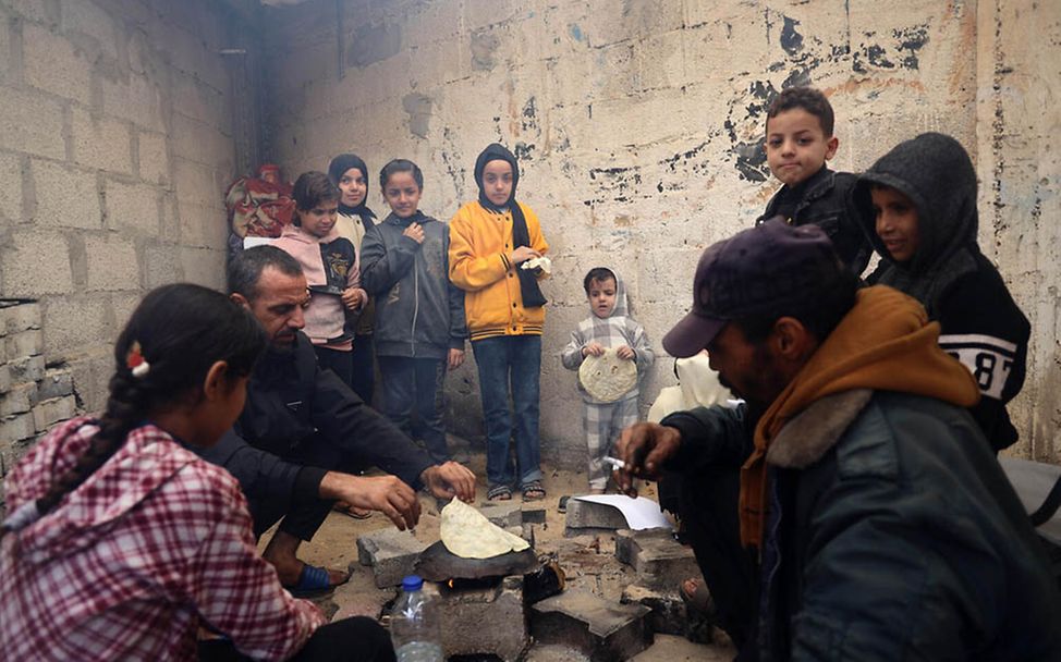 Gaza Kinder: In einer Notunterkunft in Chan Yunis backt eine Familie Fladenbrot