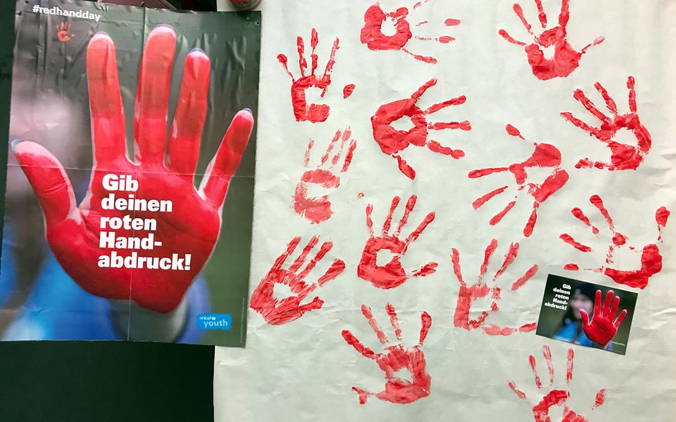 Rote Handabdrücke symbolisieren den Einsatz gegen Kindersoldaten am Red Hand Day 2024