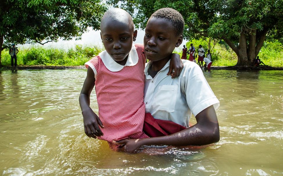 Südsudan 2021: Auf dem Nachhauseweg von der Schule hilft eine ältere Schülerin einer jüngeren. Das