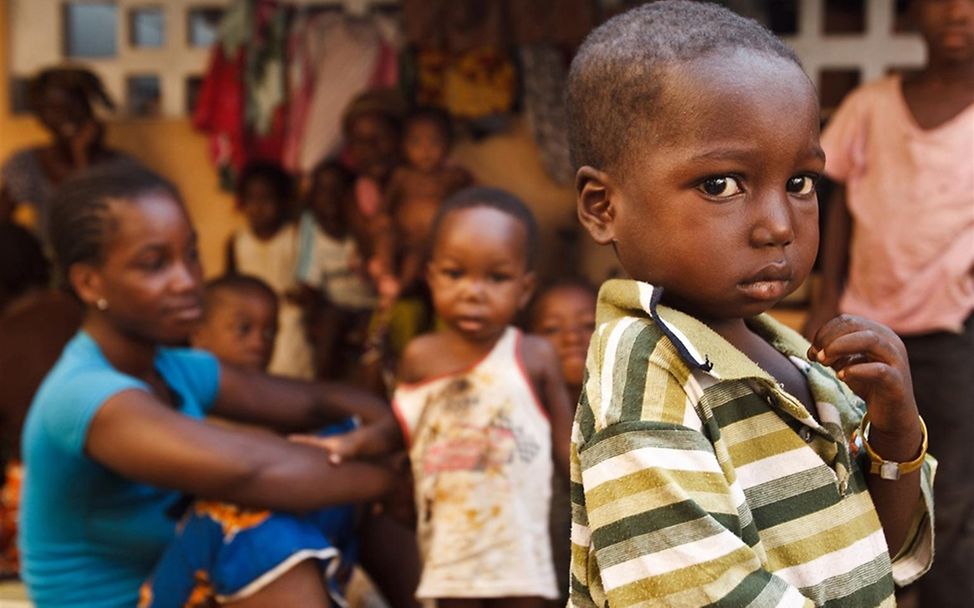 Junge mit seiner Familie in einer provisorischen Unterkunft in Duekoue. © UNICEF/Asselin