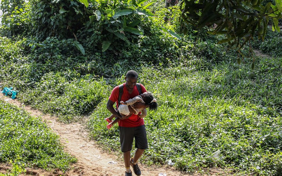 Weltflüchtlingstag: Vater und Kind kommen erschöpft nach der Überquerung des Darien Gap in Bajo Chiquito, Panama, an.