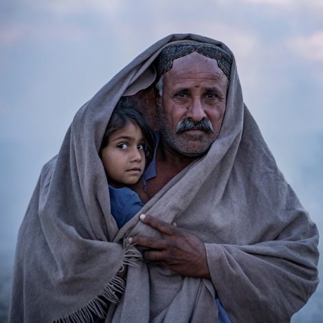 Weltflüchtlingstag: Hasol Khan bedeckt sich und seine Tochter vor seinem Zelt im Dorf Zangi Brohi in Sindh, mit einem Schal.